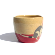 Load image into Gallery viewer, A handmade ceramic cup in a light coloured speckled clay showing the tail end of a bilby illustration and a red colour along the bottom like the desert sand.