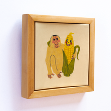 Load image into Gallery viewer, Side view of a ceramic art tile with an illustration of a monkey and anthropomorphic corn looking at each other, and with their arms around one another.