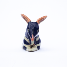 Load image into Gallery viewer, Front view of a handmade ceramic sculpture of a dark blue and white bilby with pink ears and nose.