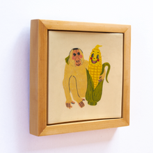 Load image into Gallery viewer, Side view of a ceramic art tile with an illustration of a monkey and anthropomorphic  corn looking at each other, and with their arms around one another.
