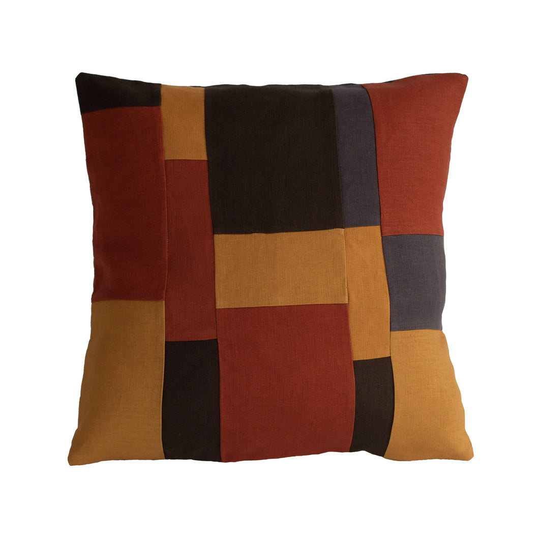 Linen patchwork cushion in the colours mustard yellow, burnt orange, dark olive green and dark grey.