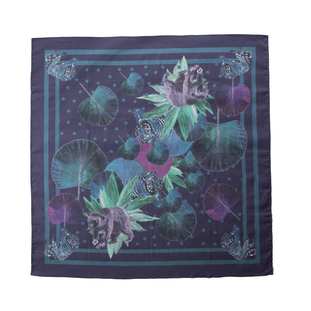 Square scarf in a blue colour with two contrasting blue lines framing the image, polkadots, a tiger and sun bear in blue, grey and black colours, and leaves in green and purple shades.