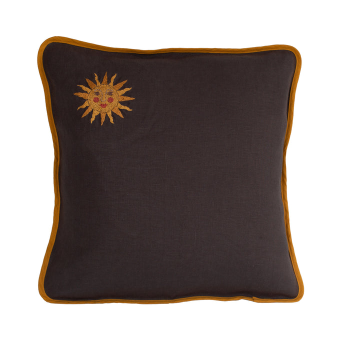 A dark grey linen cushion with mustard yellow binding with an embroidered sun illustration in the top left hand corner. The sun has a face with rosy pink cheeks.