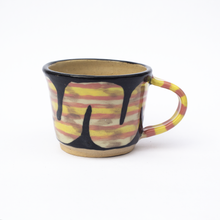 Load image into Gallery viewer, Back of handmade ceramic mug with pink and yellow striped handle and striped snake.
